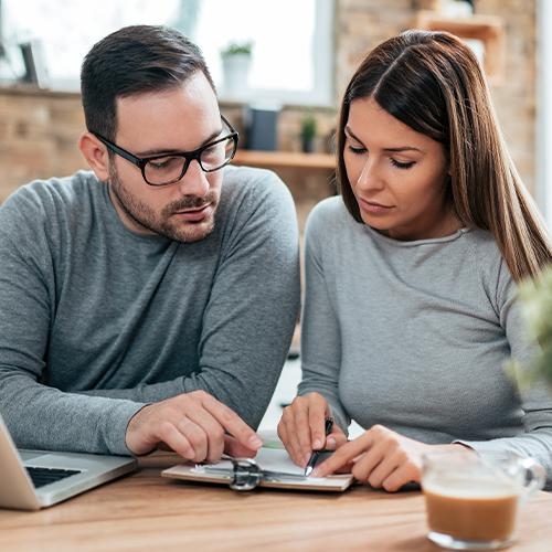 Couple behind laptop making a plan